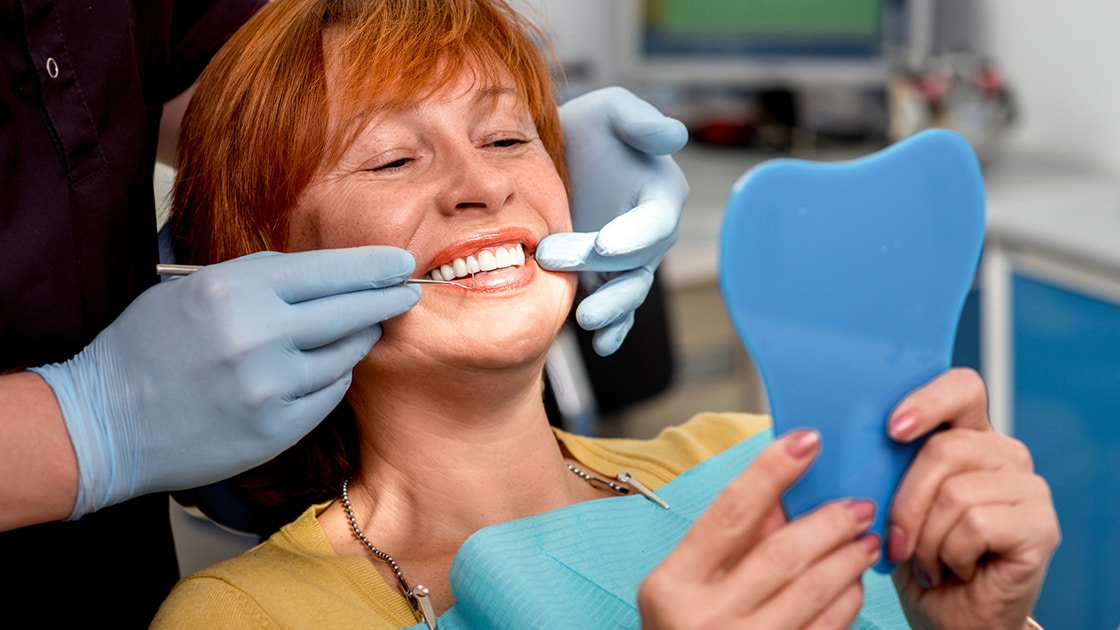 person in dental chair with dentures